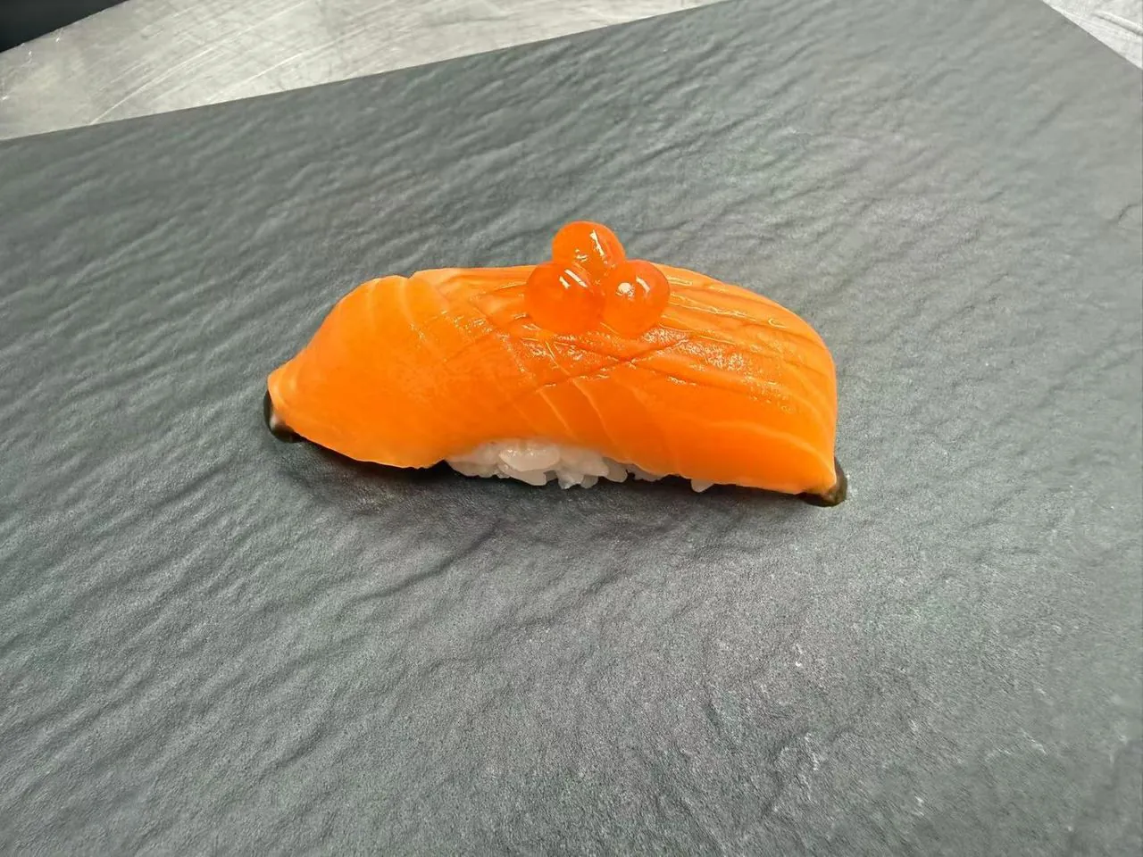 Fresh salmon nigiri topped with flying fish roe at Torii Japanese Inspired, a Japanese Restaurant in Katy