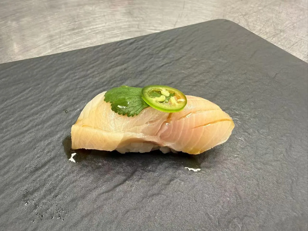 Fresh white fish nigiri with jalapeño and cilantro at Torii Japanese Inspired, a Japanese Restaurant in Katy